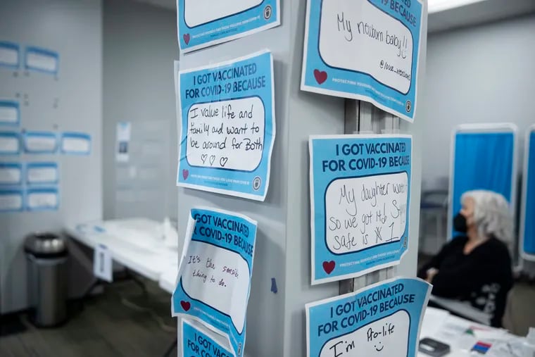 Flyers displaying people's reasons for getting the COVID-19 vaccine hang in Keystone First Wellness Center in Chester.