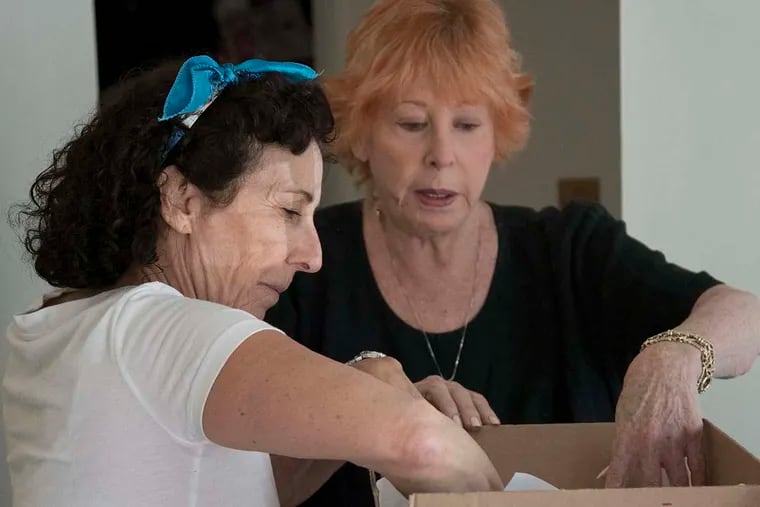 (Left to Right) Mischa Greenberg, owner/president of Moves-Made-EZ, packs a box with the help of Donna Lupschutz at Donna's home in Bryn Mawr on Tuesday, May 31st, 2016.