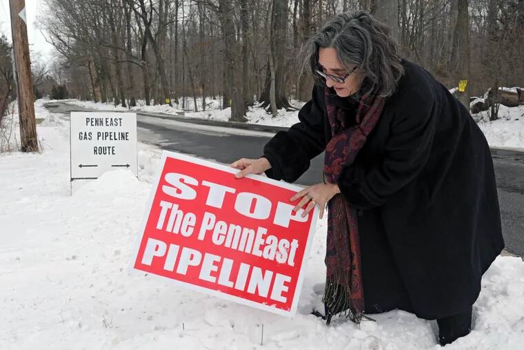Alix Bacon adjusting an anti-pipeline placard in January 2015 in Hunterdon County, N.J., near where the proposed PennEast Pipeline would cross the road.