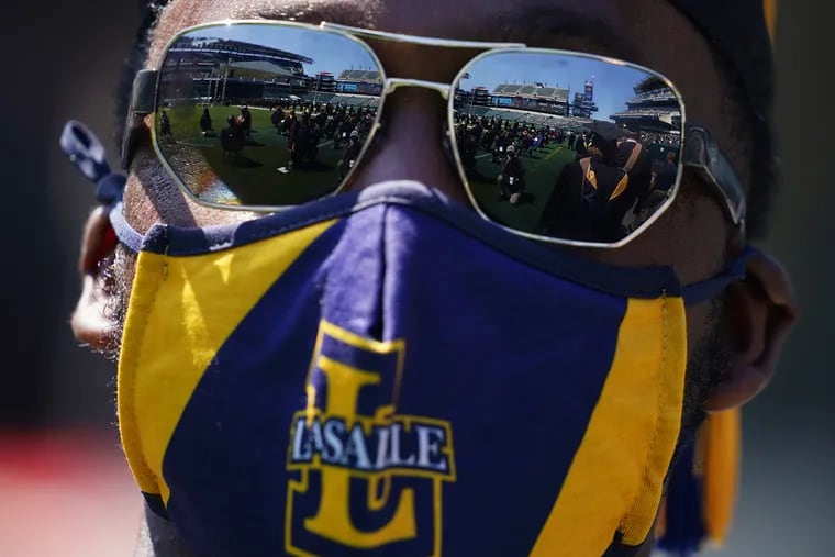 Lincoln Financial Field is reflected in sunglasses worn by Samir Inge, who was receiving his MBA, as he waited to walk onto the stage during La Salle University's Class of 2021 commencement at the stadium in South Philadelphia on Saturday, May 15, 2021.