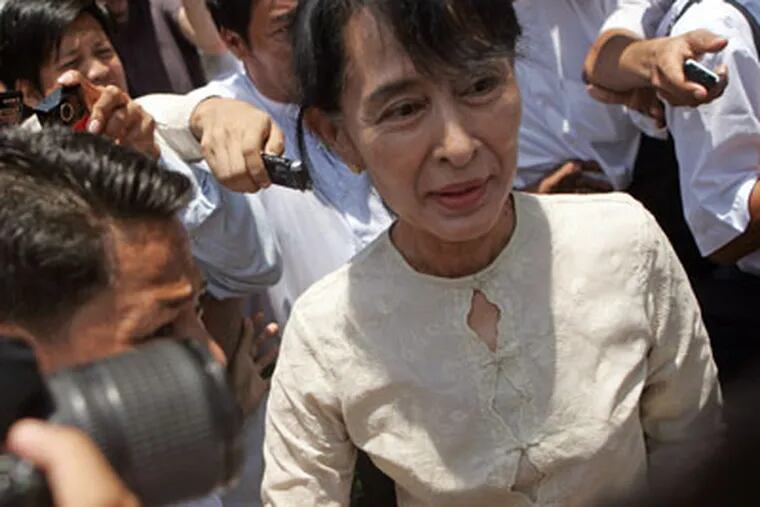 Myanmar pro-democracy leader Aung San Suu Kyi, right, leaves her National League for Democracy party after a meeting at the party's headquarters Friday, April 20, 2012, in Yangon, Myanmar. After opposition leader Aung San Suu Kyi's party swept special elections this month, the Obama administration said it would ease restrictions on financial services and investment.  (AP Photo/Khin Maung Win)