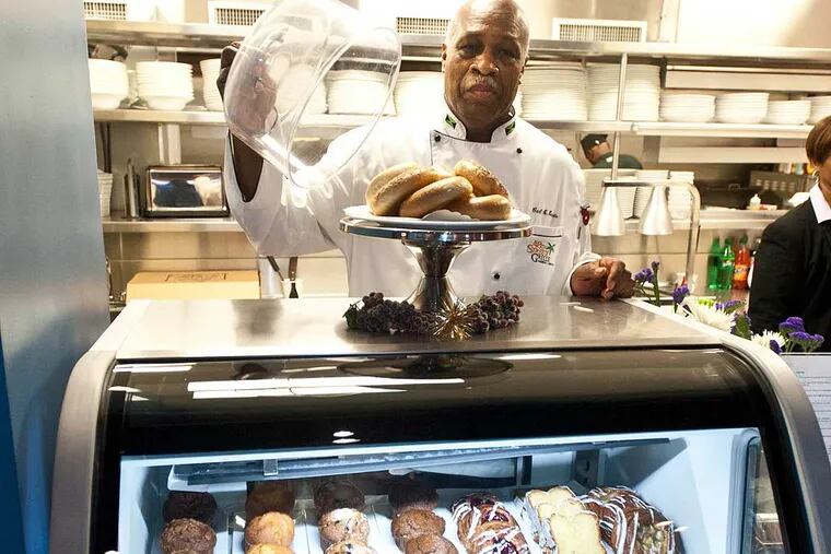 Carl Lewis, owner of 48th Street Grille in West Philadelphia, behind the refrigerated display case he bought with a Kiva loan. ( RON TARVER / Staff Photographer )