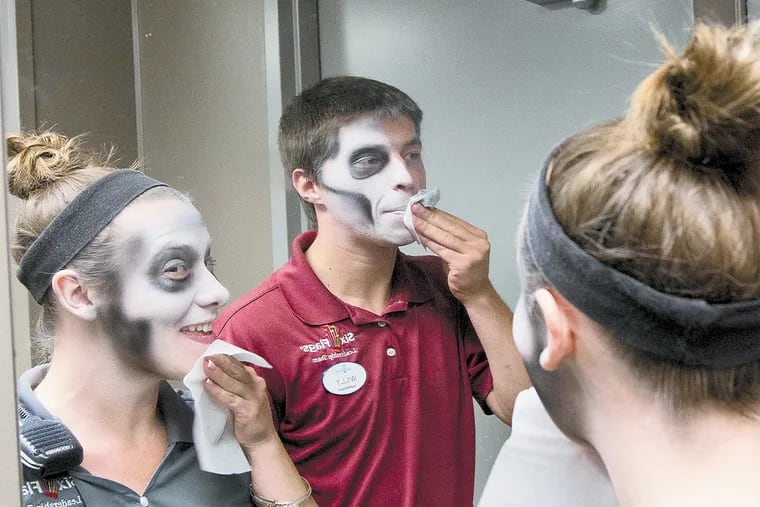 Alex Volper and Derek DiPasquale, both supervisors of entertainment, wipe their zombie paint from their face after being models for a make-up artist audition during zombie tryouts at Great Adventure, Jackson. ( DAVID M WARREN / Staff Photographer )
