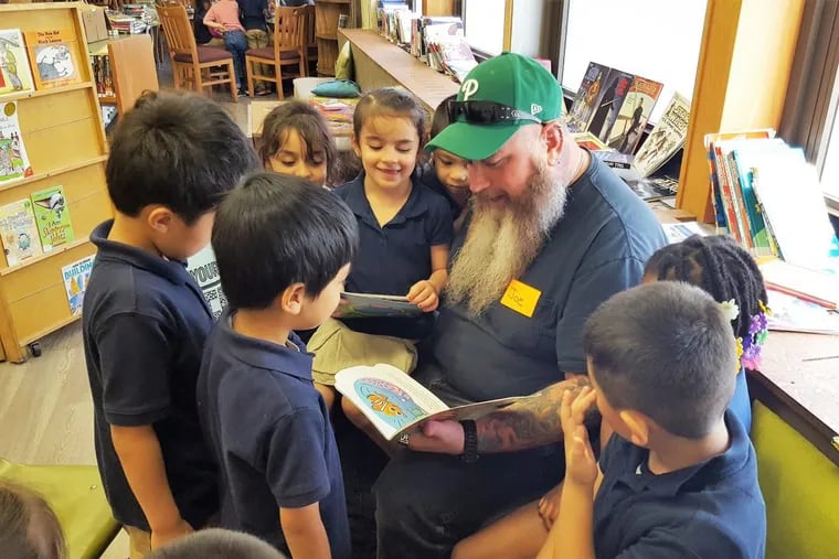 Joe Chirik, RevZilla customer service team leader, reads to Mary Kaplan’s kindergarten class at John H. Taggart Elementary School in South Philly. RevZilla is in its second year as a corporate partner of Taggart.