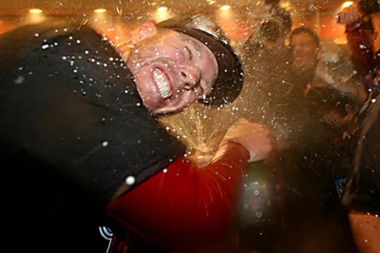 Roy Halladay gets a shower of champagne as the Phillies celebrate their 5th straight divisional title.  (Charles Fox/Staff Photographer)