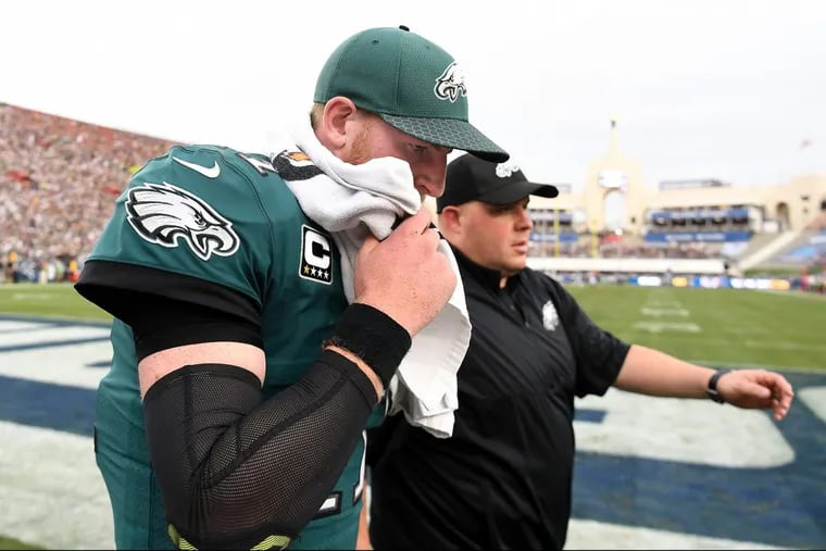 Philadelphia Eagles quarterback Carson Wentz walks off the field after injuring his leg against the Los Angeles Rams on Sunday at the Coliseum in Los Angeles.