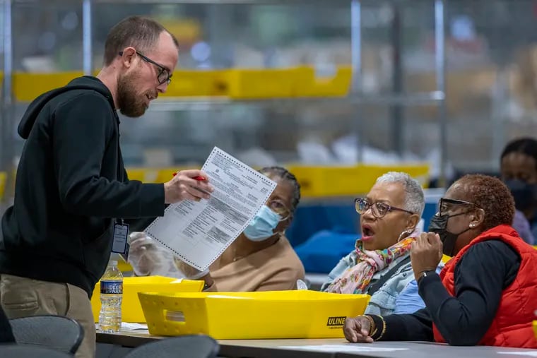 Workers review mail ballots in Philadelphia on Election Day 2022.