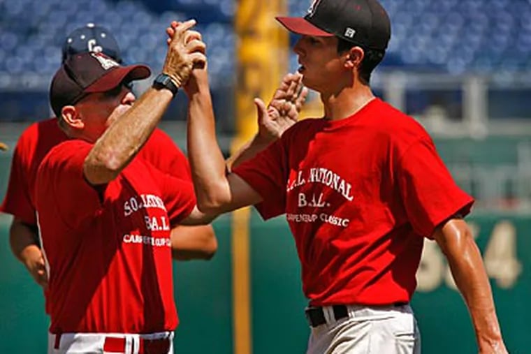 SOL National / Bicentennial pitcher Jake Ruch and assistant coach Dave Torresani celebrate after defeating SOL American & Continental. (Alejandro A. Alvarez / Staff Photographer)
