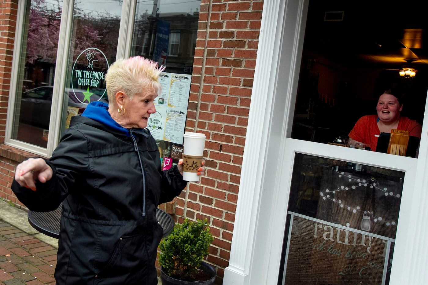 Regular Pat Curiale (left) of Audubon gets her usual “jumbo” cup of coffee from manager/barista Casey Colgate (right) at the Treehouse Coffee Shop and Cafe in downtown Audubon, N.J. Mar 25, 2020.