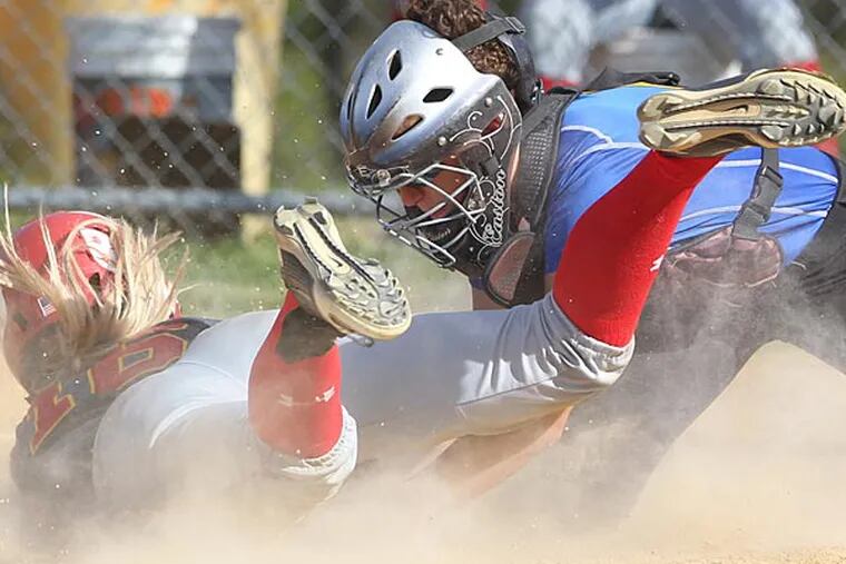 Amy Atwell, left, of West Chester East is tug out at home by catcher
Brigette Nordberg of Downingtown East in the 5th inning of their game
on May 3, 2013. Atwell tried to tag and score on a  foul pop fly that
was caught. (Charles Fox/ Staff Photographer )