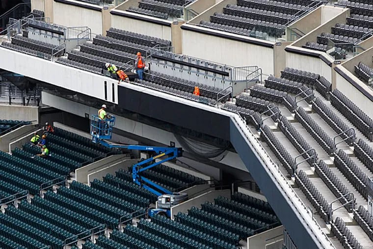 Construction Workers add LED ribbon board. (Michael S. Wirtz/Staff Photographer)