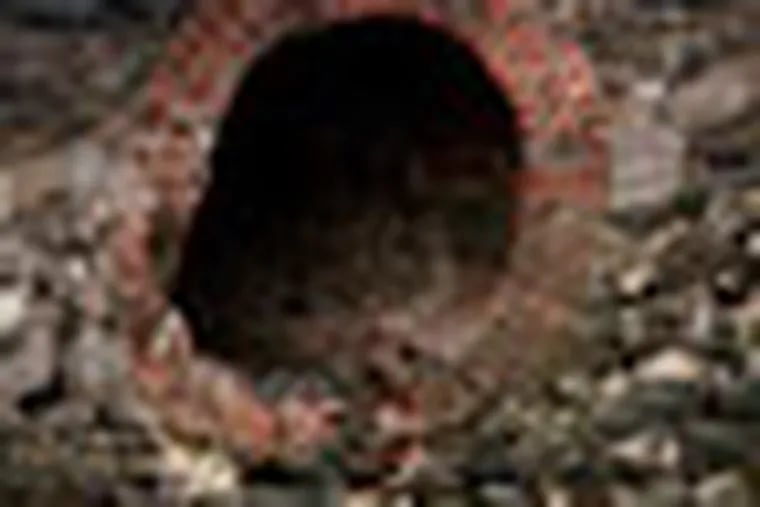 FILE - This file photo of March 2, 2010 shows a brick-lined drain pipe feeding into Gowanus Canal, which was added to the Superfund National Priorities List in 2010 for being heavily contaminated with PCBs, heavy metals, volatile organics and coal tar wastes. New York, New Jersey and EPA officials say toxic sites are OK after superstorm Sandy, but the Associated Press has found that few actual tests have been done. (AP Photo/Mark Lennihan, File)