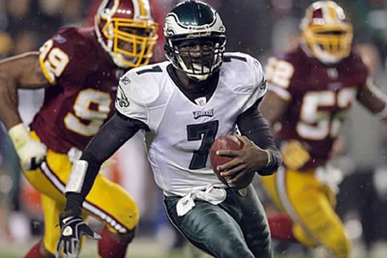 Michael Vick threw for four touchdowns and ran for two more in the Eagles' win. (Yong Kim/Staff Photographer)