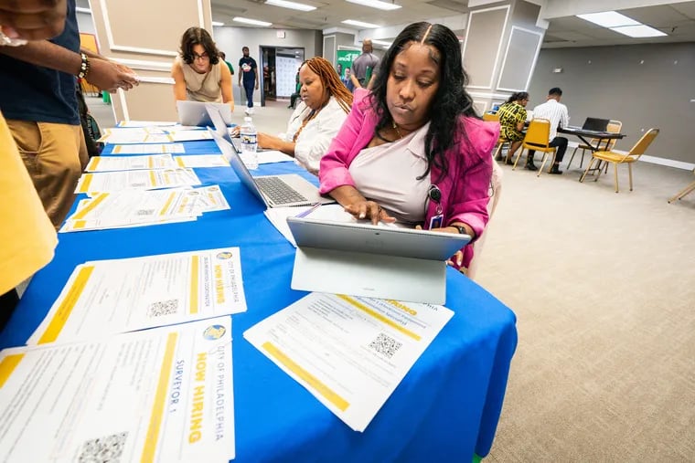 In this August file photo, Lisa Pace, a Senior Human Resource Analyst Over Recruitment, (seated right), talks with applicants at a job fair intended to improve hiring for city government jobs.