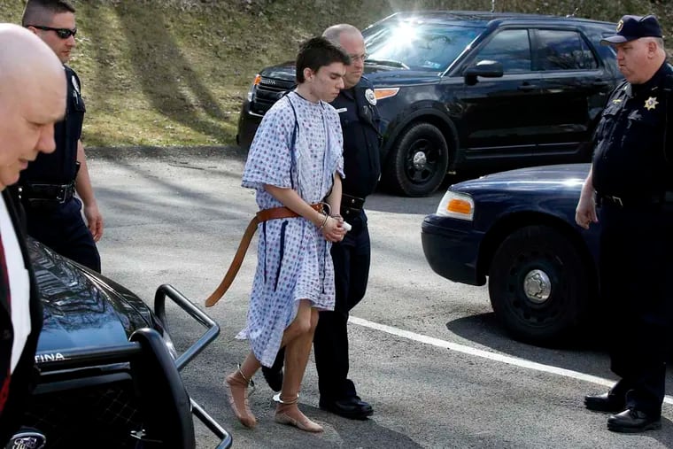 Alex Hribal, the suspect in the multiple stabbings at the Franklin Regional High School in Murrysville, Pa., is escorted by police to a district magistrate to be arraigned on Wednesday, April 9, 2014, in Export, Pa. Authorities say Hribal has been charged after allegedly stabbing and slashing at least 19 people including students in the crowded halls of his suburban Pittsburgh high school Wednesday. (AP Photo/Keith Srakocic)