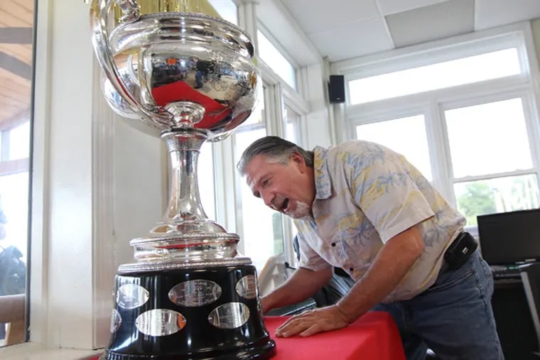 Phil Fivey, a Cooper River Yacht Club member, takes a closer look a the 2013 Qualcomm Star World Championship trophy as it sat in the clubhouse of the yacht club during a party being held for John MacCausland, who won it.  09/15/ 2013 (MICHAEL BRYANT / Staff Photographer)