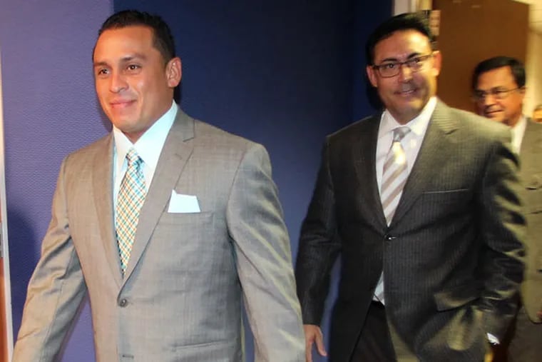 Carlos Ruiz enters the interview room with team General Manager Ruben Amaro, Jr. (Yong Kim/Staff Photographer)