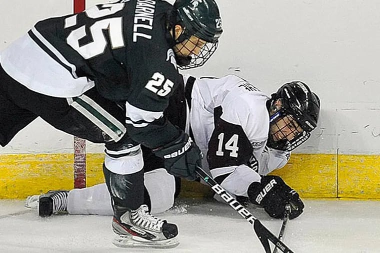 Michigan State's Brent Darnell, left, and Union College's Shayne Gostisbehere, right, fight for control of the puck during the second period of an East regional semifinal game in the NCAA college hockey tournament in Bridgeport, Conn., Friday, March 23, 2012. (AP Photo/Jessica Hill)