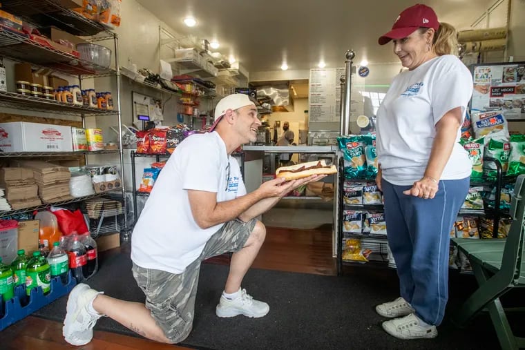 When Nick Maiale Jr. of Lil' Nick's Deli asked Kristi Giancaterino to marry him, a sandwich, named the Kristi, was part of the proposal. Sandwiches were only named after family members so she knew the proposal was next. They clown around as Nick takes a knee for the photo. He did not go down on a knee for the actual proposal.