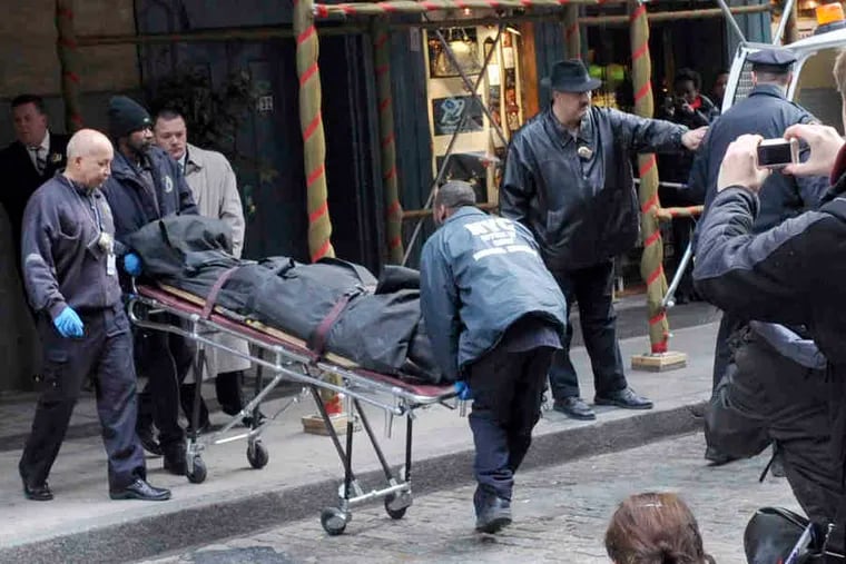 Workers from New York City's Chief Medical Examiner's Office remove Mark Madoff's body from the Manhattan apartment where he lived and was found hanged.