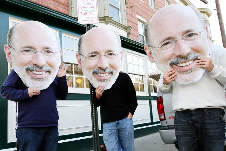 IBEW Local 98 members, who didn't want to give their names, hold up large photos of Tom Wolf's face outside Famous 4th Street Deli in Philadelphia on Election Day on November 4, 2014.  ( DAVID MAIALETTI / Staff Photographer )