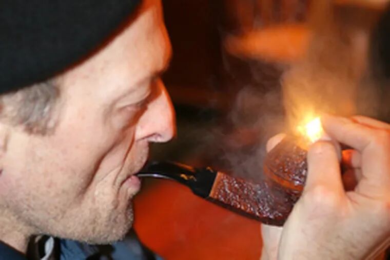 Louis Zisholz lights up during the Christopher Morley Pipe Club meeting at the Pen & Pencil Club last month.