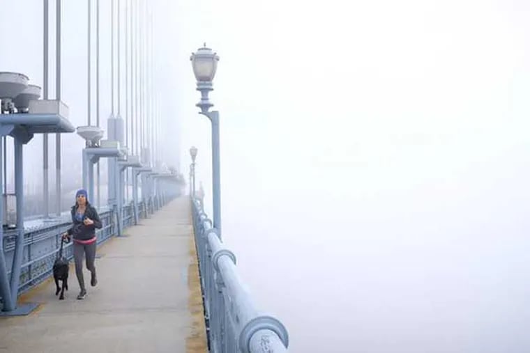 Fog over the Delaware River and Benjamin Franklin Bridge on Monday, Dec. 14, 2015.