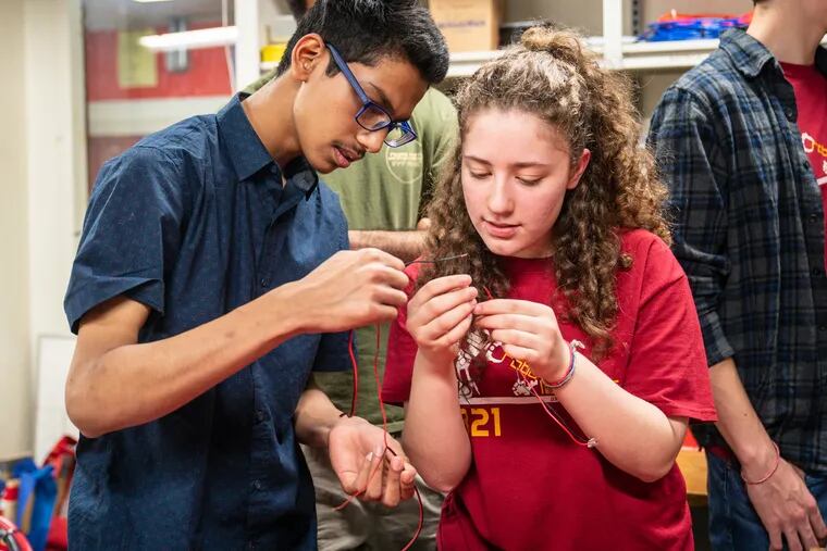 Abrar Kazi and Lilianna Sand, members of the RoboLancers, work with wires in the process of demonstrating a soldering technique at Central High School.