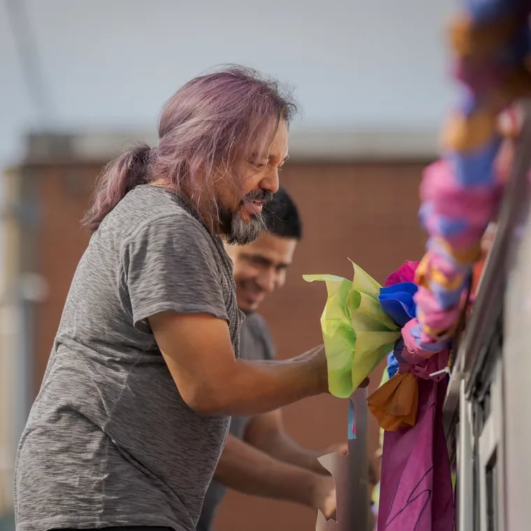 César Viveros, the lead visual artist for the short film La Guagua 47, adds flowers to a SEPTA bus for the film. Viveros and other community leaders created Street Knowledge, a program offering free and low-cost classes taught by community members, for community members.