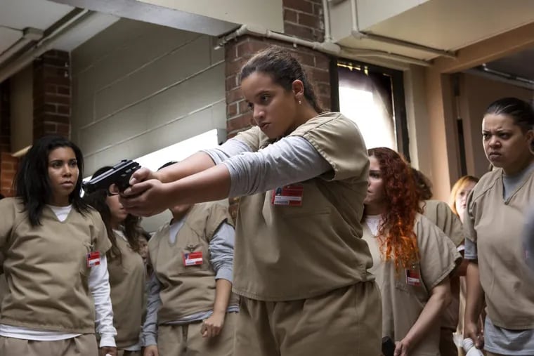 Dascha Polanco (center, with gun) in a scene from Netflix’s “Orange Is the New Black”