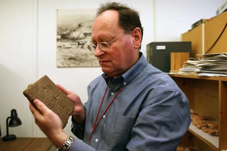 Grant Frame, associate curator of the Babylonian section of the Penn Museum, holds a clay tablet with the story of Gilgamesh recorded on it in cuneiform. He is coordinating the gathering at the Penn Museum.