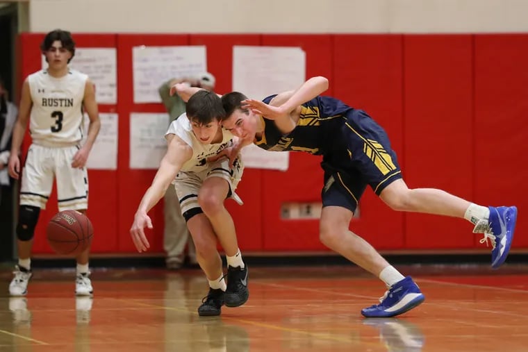 Dan Wethey, center, of West Chester Rustin and Logan Shanahan, right, of Unionville go after a loose ball in the 2nd half of a second round game of the PIAA Class 5A boys' basketball tournament on March 10, 2020.   Peter Reinheimer is left.