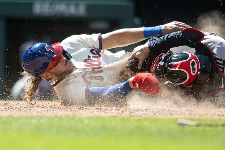Philadelphia Phillies' Alec Bohm, left, is tagged out by Atlanta Braves catcher Travis d'Arnaud while trying to score on a run-scoring double by Bryson Stott during the fifth inning of the first baseball game in a doubleheader, Monday, Sept. 11, 2023, in Philadelphia.