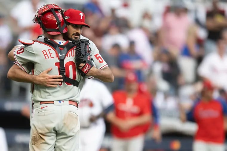 Phillies catcher J.T. Realmuto and pitcher Zack Eflin embrace after winning Game 1 over the Braves.
