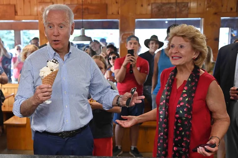 President Joe Biden buys ice cream as Michigan Sen. Debbie Stabenow (right) looks on at Moomers Homemade Ice Cream in Traverse City, Mich., in July. Biden's folksy language can carry a big impact, writes Jeffrey Barg.