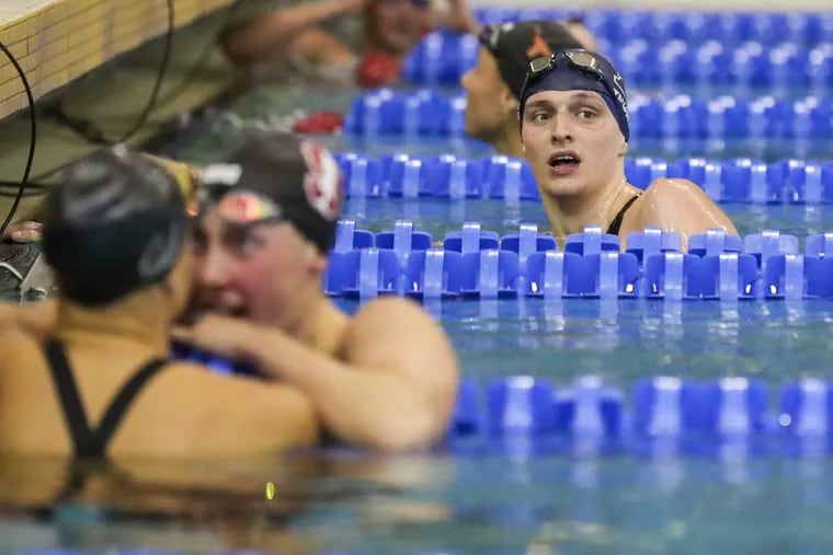 Penn’s Lia Thomas (right) looks on as Stanford’s Taylor Ruck, left, who finished in first place, reacts with University of California Berkeley’s Isabel Ivey, who finished in second place, after the 200-yard freestyle final at the McAuley Aquatic Center in Atlanta on Friday, March 18, 2022. Thomas finished in fifth place.