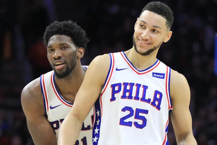 Joel Embiid, left, of the Sixers grabs Ben Simmons from behind as he celebrates a pass Simmons made to Dario Saric against the Pistons at the Wells Fargo Center on Dec. 2, 2017.