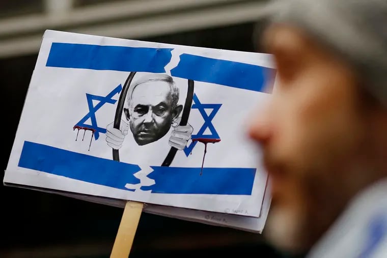 A picture of Israeli Prime Minister Benjamin Netanyahu behind bars is seen as members of the Israeli and Jewish communities gather to protest outside the Israeli Consulate in New York, March 27, 2023, during an emergency rally for Israeli democracy.