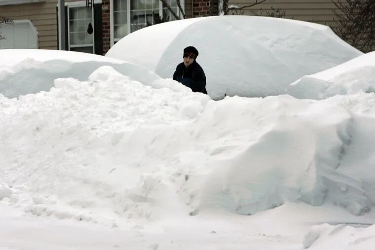 A man shovels cars out from under mountains of snow in West Bradford, Chester County, during the incredible snow siege of February 2010.