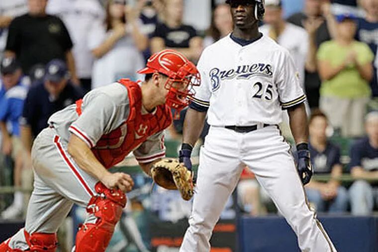 Milwaukee Brewers' Mike Cameron (25) reacts to a called third strike in front of Philadelphia Phillies catcher Paul Bako to end the ninth inning of a baseball game Sunday, Sept. 27, 2009, in Milwaukee. The Phillies won 6-5. (AP Photo/Morry Gash)