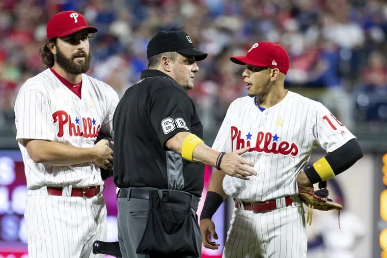 Phillies reliever Austin Davis (left) talks to home-plate umpire Marty Foster about why he wasn't allowed to refer to an index card with notes on Chicago Cubs hitters while he pitched in the eighth inning Saturday night.