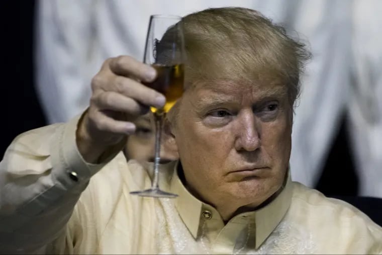 President Trump holds up his glass during a toast at an ASEAN Summit dinner in Manila Sunday.