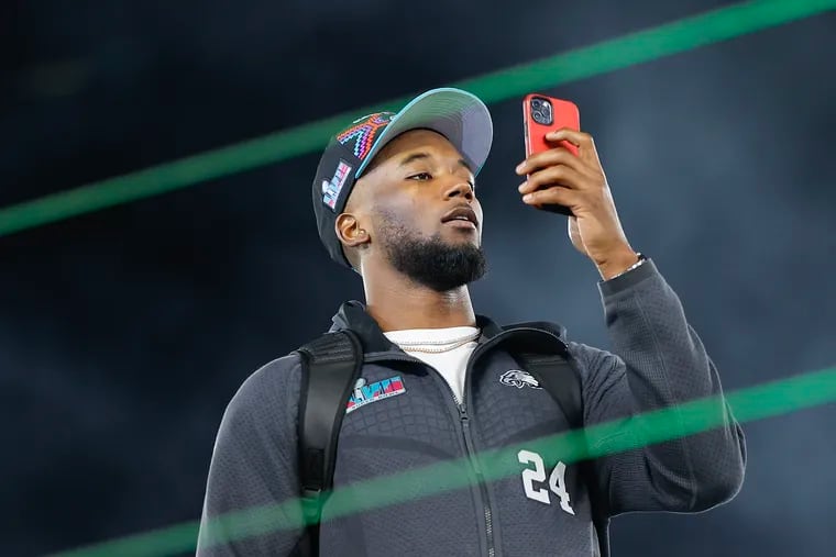 Eagles cornerback James Bradberry uses his cell phone to record Super Bowl LVII's opening night Monday at the Footprint Center in Phoenix.