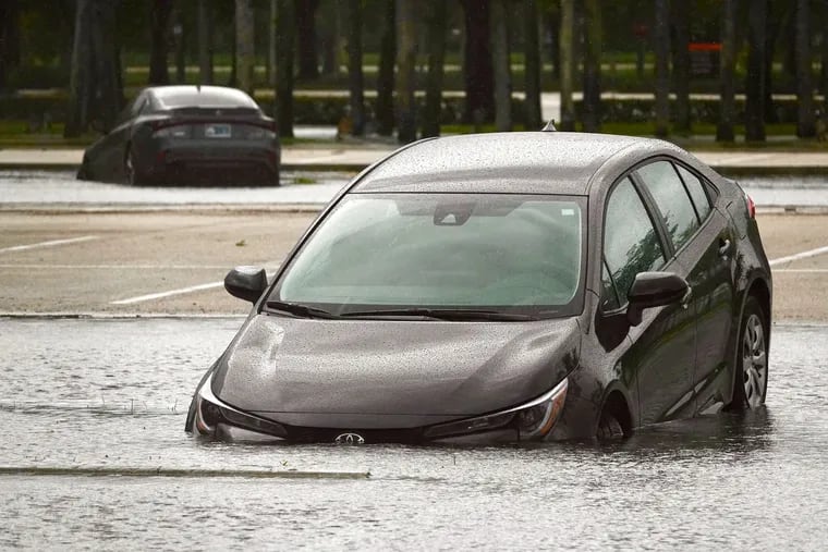 A car sitting in a flooded parking lot at Sawgrass Mills in Sunrise, Fla., on Sept. 28, after parts of South Florida received nearly 10 inches of rain over three days from Hurricane Ian.
