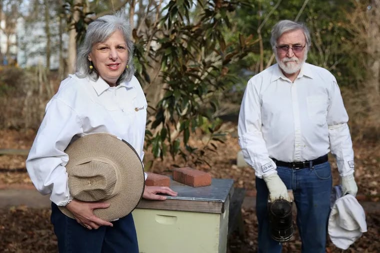 Maria, left, and Bob Esche next to their beehive outside their home in Moorestown, N.J. They are sharp critics of proposed state regulations they say will discourage backyard beekeepers like themselves from pursuing the hobby.
