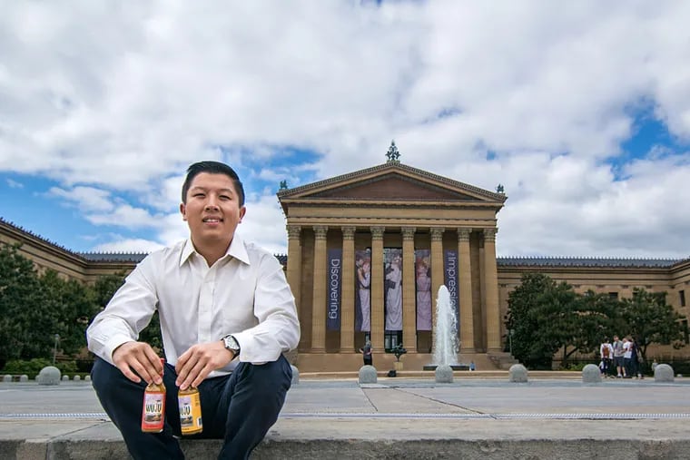 Lawrence Wu holds a bottle of his WUJU hot sauce on the steps of the Philadelphia Museum of Art. Wu, 24, used Kickstarter to launch a successful crowdfunding campaign to produce the hot sauce.