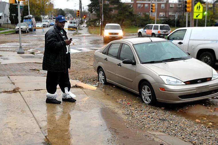 Ronald Robinson surveys mud and water damage in his Eastwick neighborhood this morning. A water main break at 64th Street and Lindbergh Boulevard flooded the street for the second time in six months.