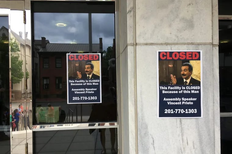 Posters outside the governor's office in Trenton blame Assembly Speaker Vincent Prieto for the shutdown.