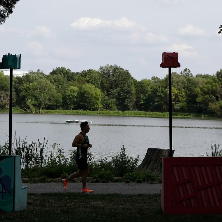 A runner along Edgewood Lake with birdhouse in view at FDR Park in August 2022.