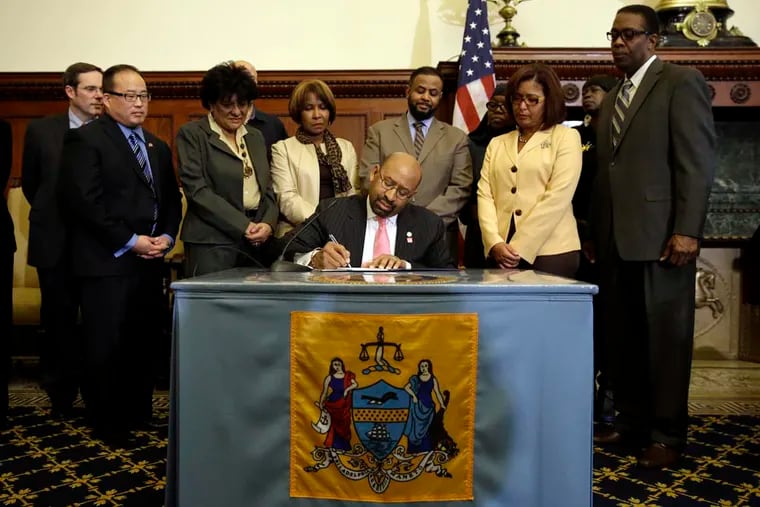 Philadelphia Mayor Michael Nutter signs an ordinance during a ceremony, Monday, Jan. 13, 2014, at City Hall in Philadelphia, creating a municipal land bank.